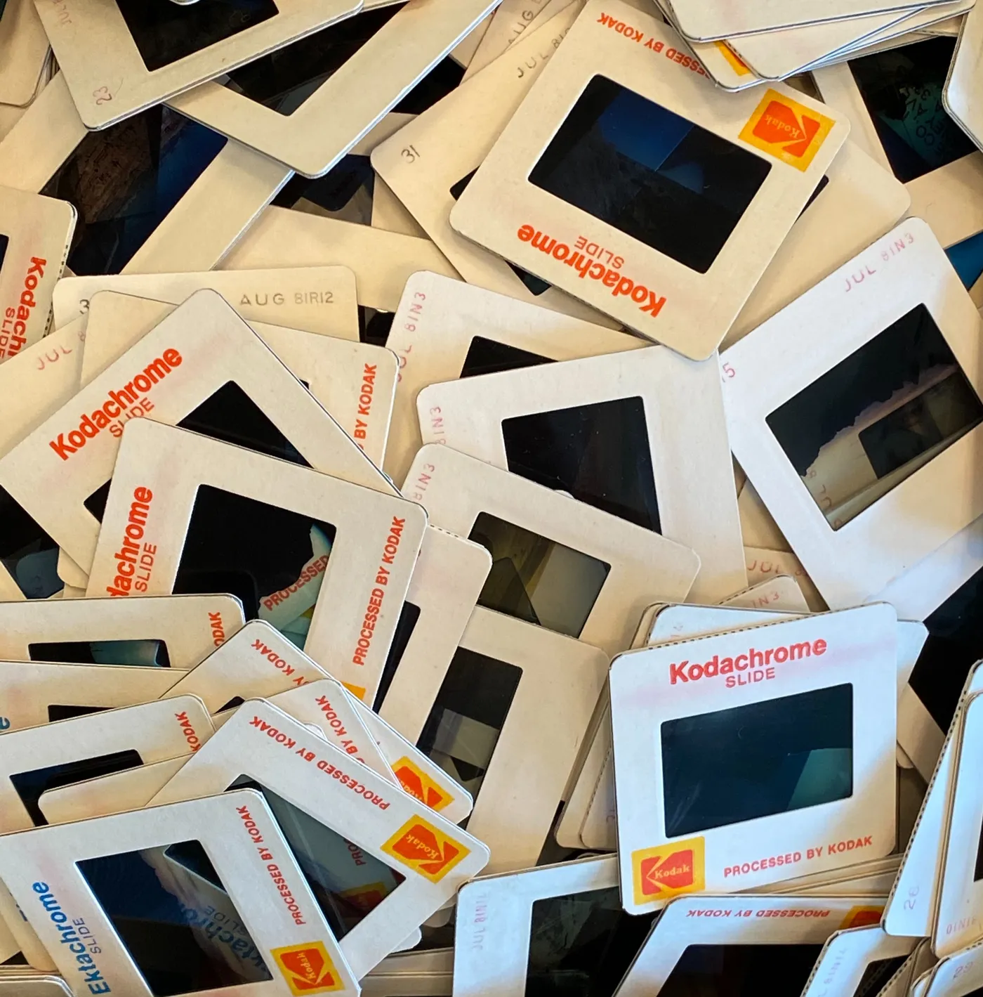 A pile of vintage Kodachrome slide mounts, stamped with dates from the 1960s and 70s